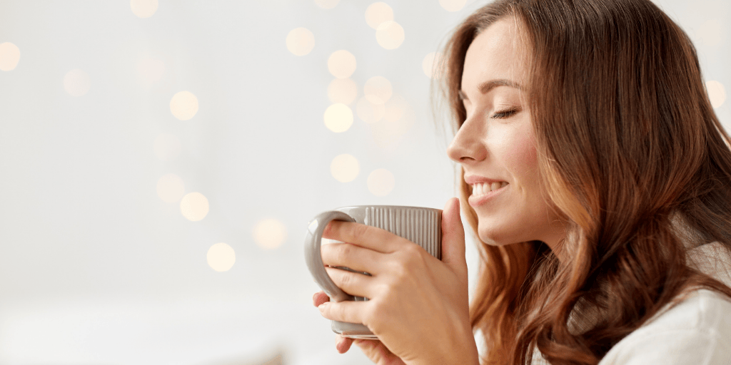 Frau mit einer Tasse, die sich wohlfühlt